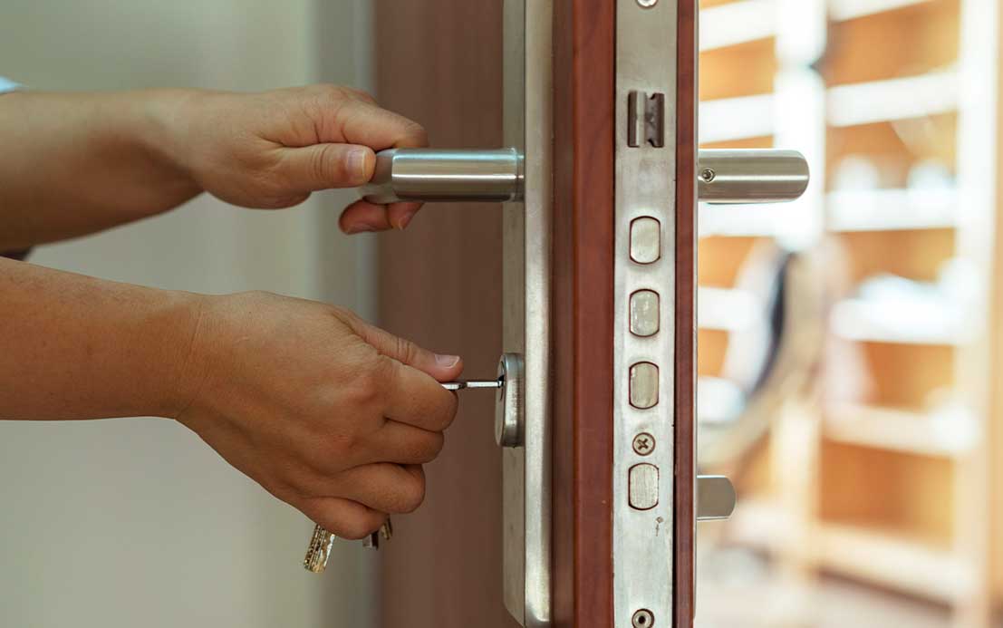 Imagen de una puerta abierta con la cerradura visible, cerrajero trabajando
